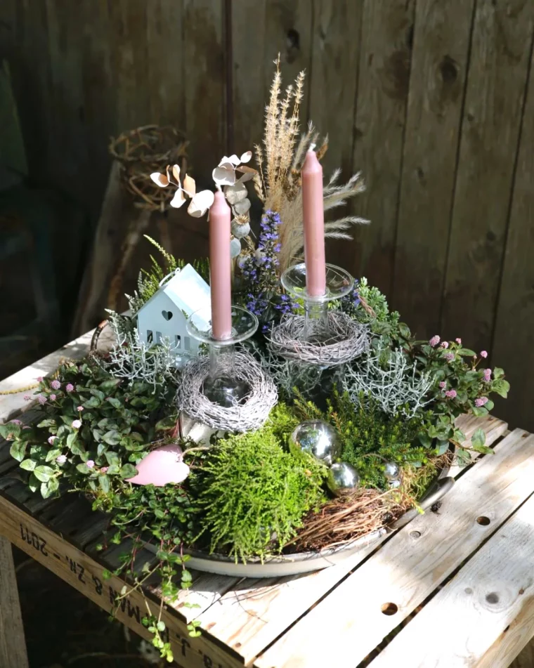 panier de noel en tant que decoration exterieure avec de la mousse et de la verdure deux bougies