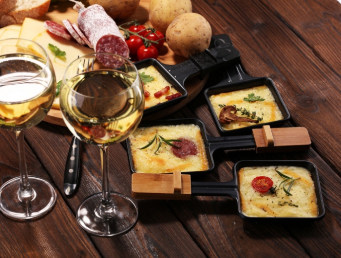 raclette présentation coupelles remlies de fromage charcuterie et légumes vin blanc