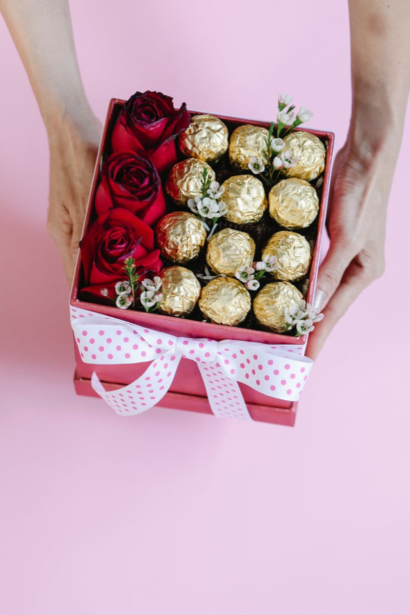 coffret saint valentin femme plein de bonbons au chocolat et roses dans une boite