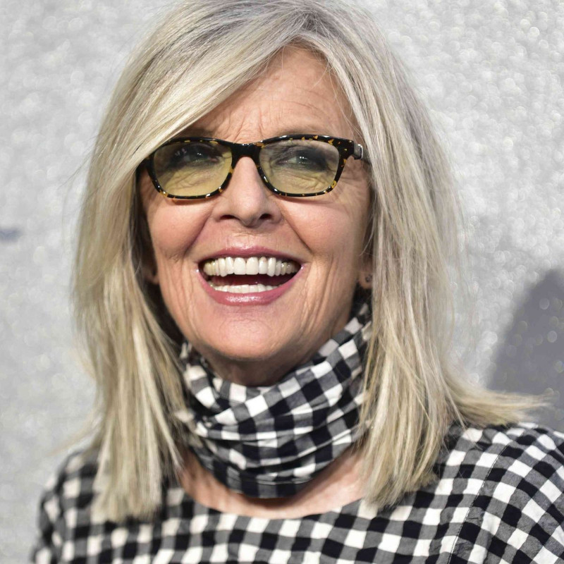 Hairstyle of a 60-year-old half-long lady Diane Keaton with glasses and a black and white outfit