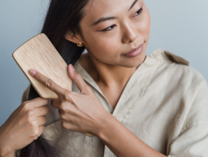 comment nettoyer une brosse à cheveux une femme qui peigne ses cheveux