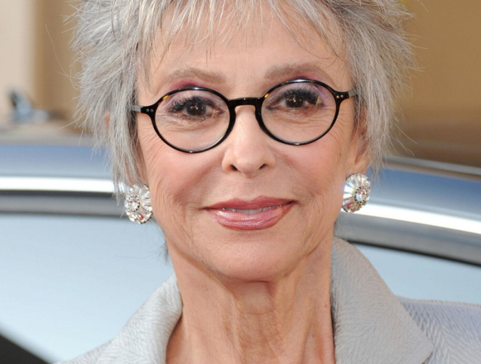 coupe cheveux blancs femme 60 ans lunettes aux montucules rondes noires veste grise