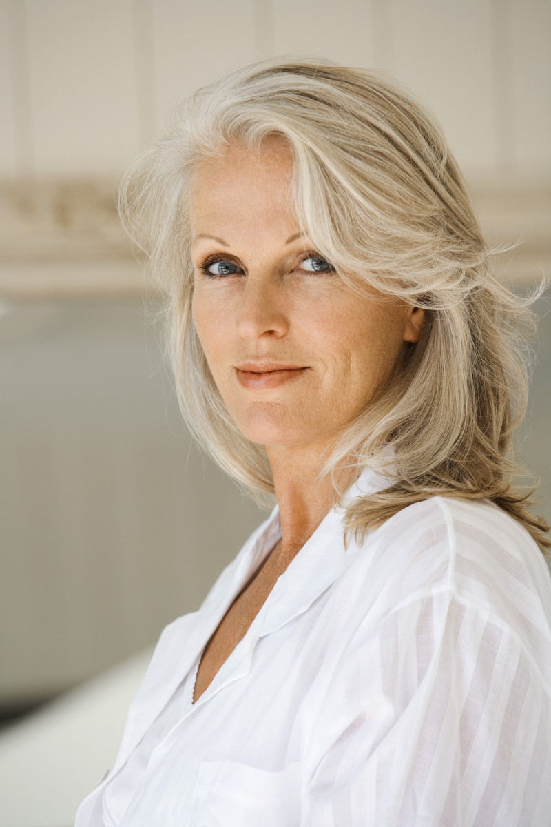 coupe de cheveux mi long dégradé platines avec frange laterale femme en chemisier blanc