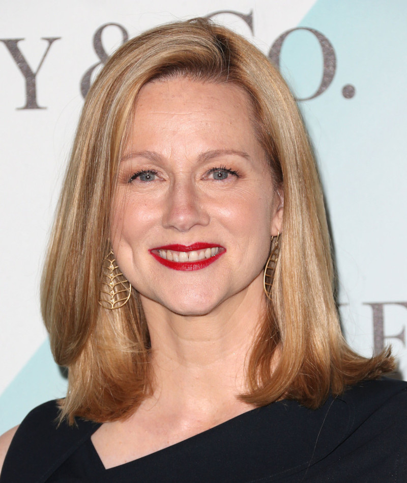 Haircut for a round face for a 50-year-old woman, blond Laura Linney in a black dress