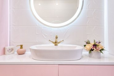 décoration toilettes salle de bain rose avec un miroir à éclairage integré