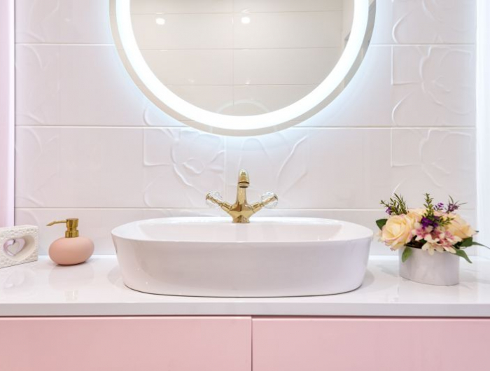 décoration toilettes salle de bain rose avec un miroir à éclairage integré