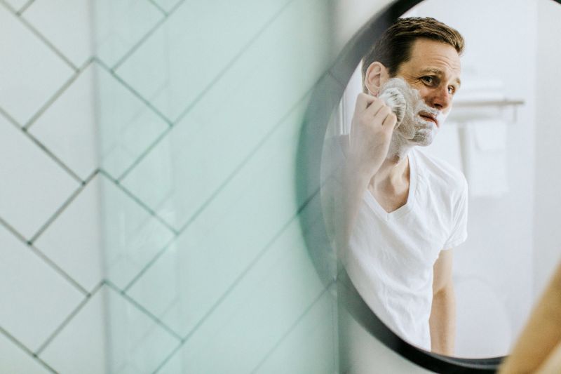 décoration toilettes un homme qui se fait la barbe devant le mirroir