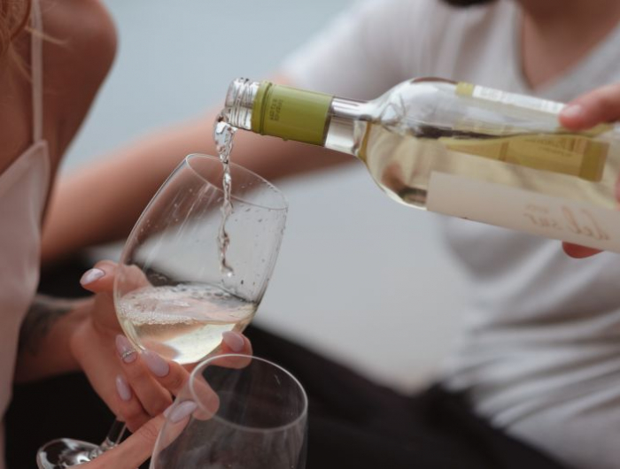 diner romantique verser du vin blanc dans les verres