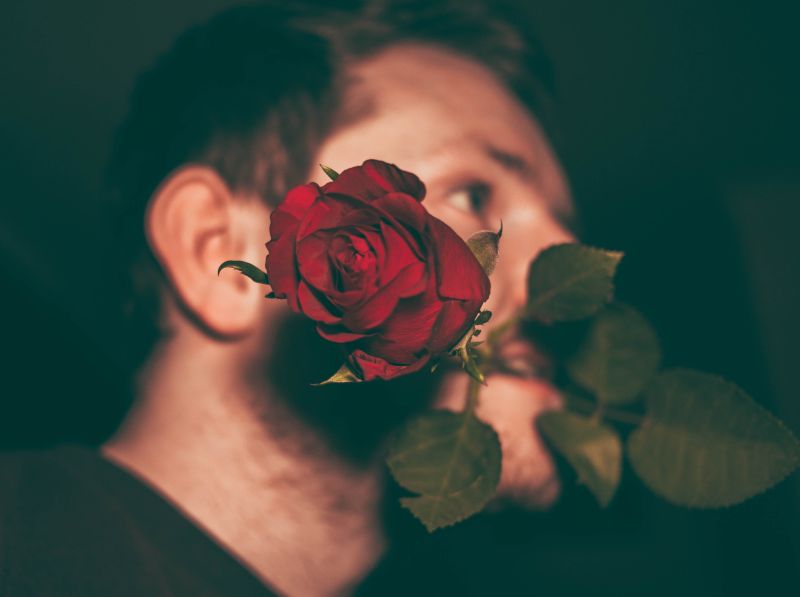 faire une surprise à son amoureux un homme avec une rose à la bouche