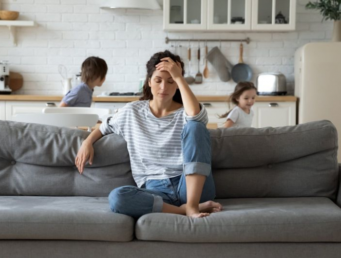 fatigue émotionnelle une mère fatiguée sur le canapé et des enfants qui jouent