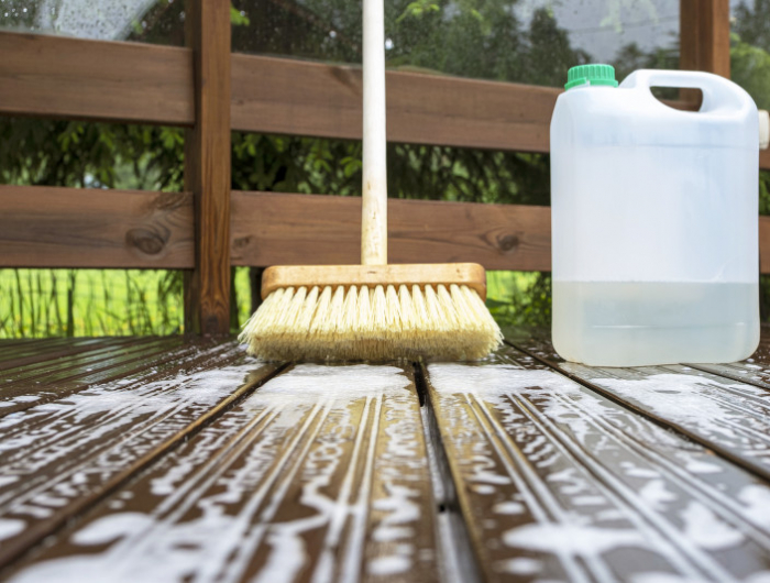 brush, plastic canister with mortar and soapy water on wooden terrace boards