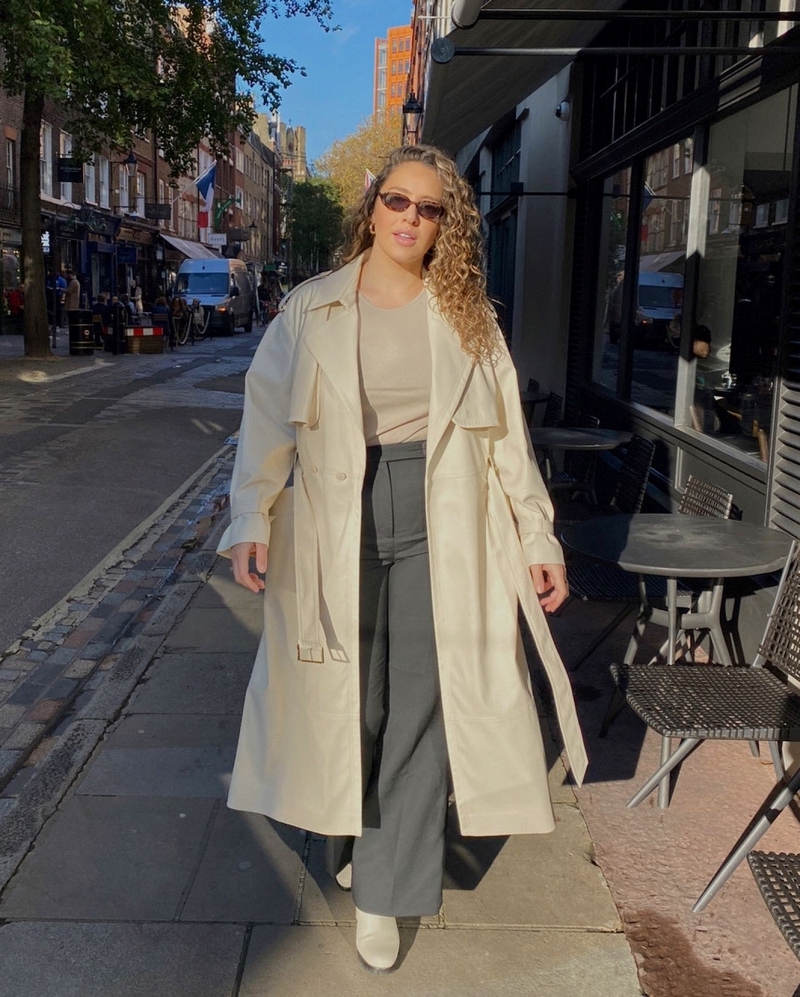 curvy woman flowing pants gray t-shirt nude trench coat