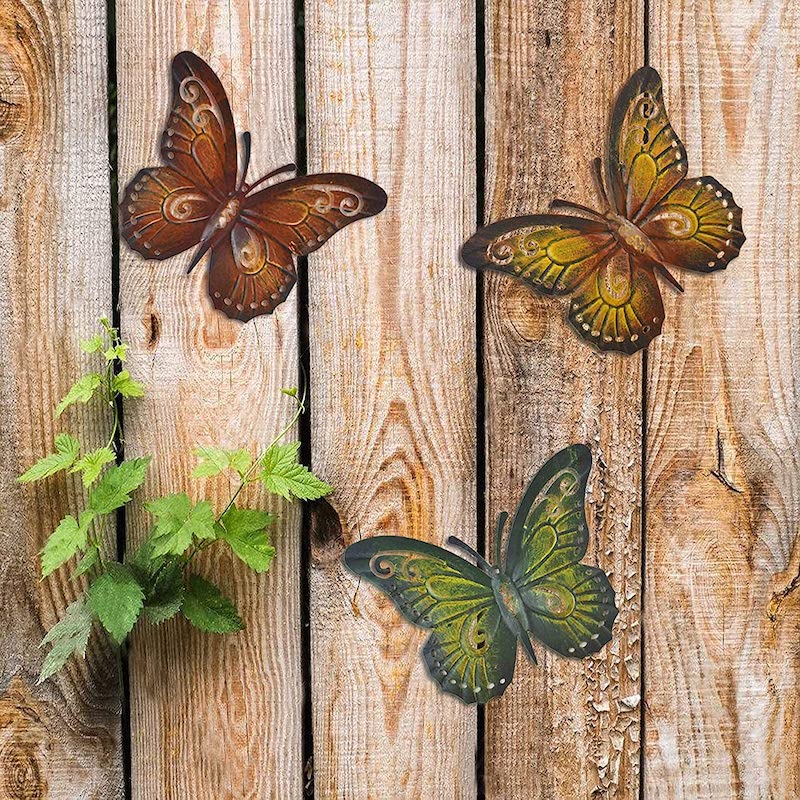 modele de decoration murale exterieur en metal papillons colores sur mur bois