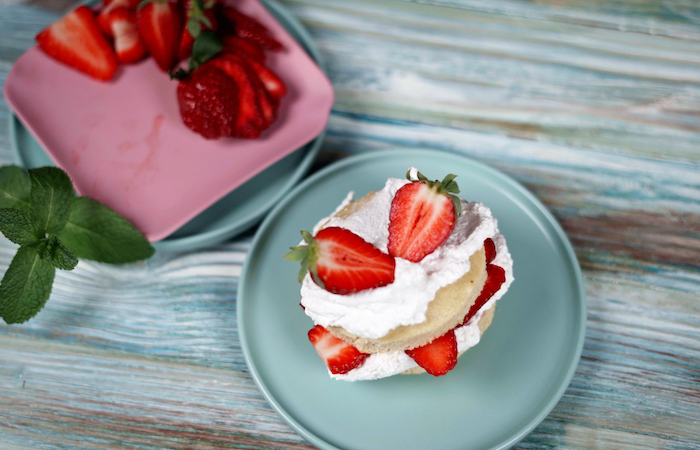 ranger des moitiés de fraises dessus dessert a base de fraises creme fouettee biscotte sans gluten et fraises