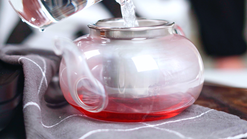 ajouter de l eau bouillante dans une théière pour faire un thé d hibiscus recette boisson ayurvédique