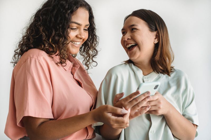 deux filles qui rient devant un portable en faisant un test de personnalite