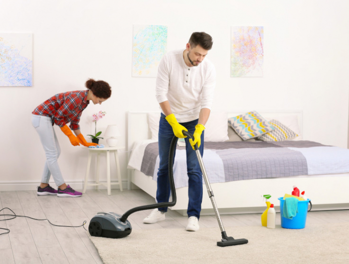 happy young couple cleaning home together