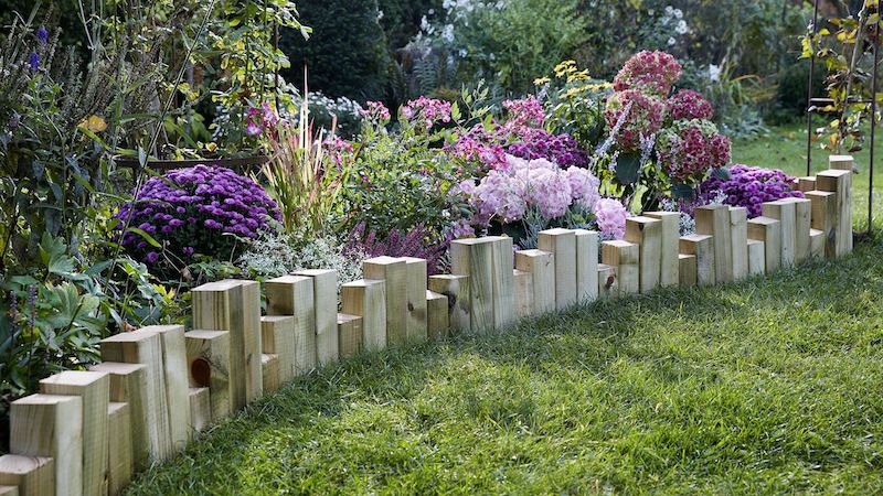 modele de bordure massif de bois avec des blocks bois d une haueur variée pour limiter parterre de fleurs
