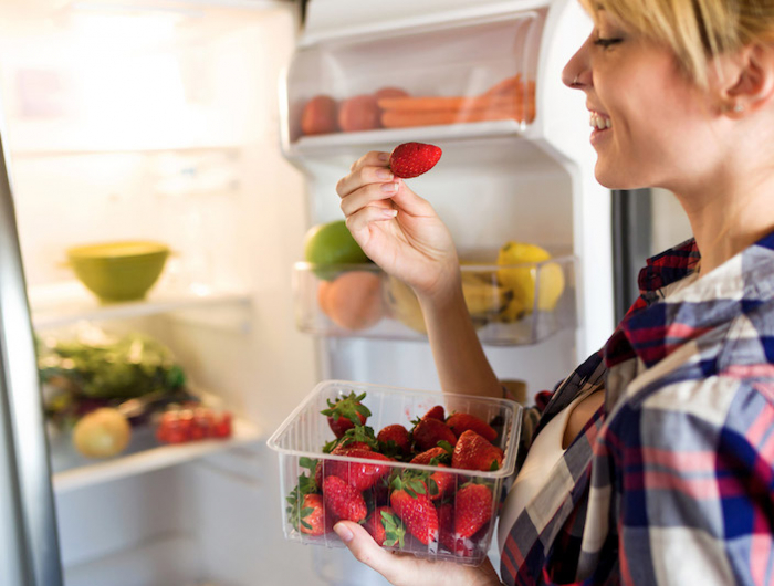 10 bienfaits des fraises femme conservant des fraises dans un rzfrigerateur