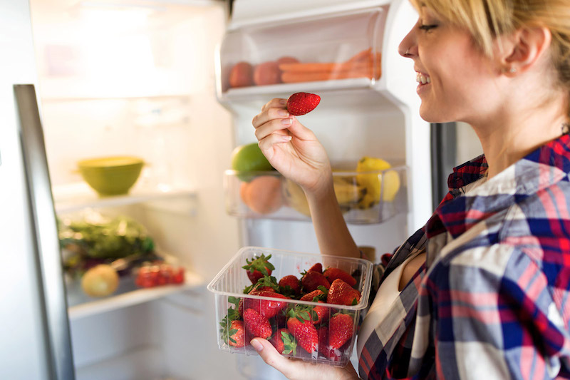 10 bienfaits des fraises femme conservant des fraises dans un rzfrigerateur