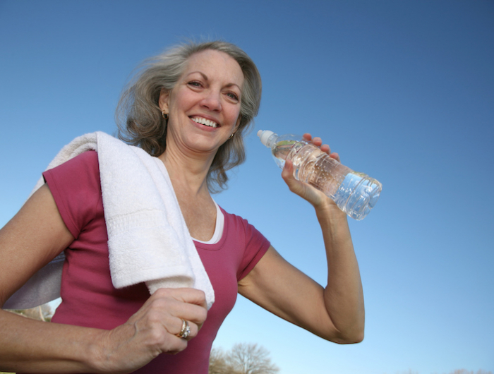 smiling active adult drinking water