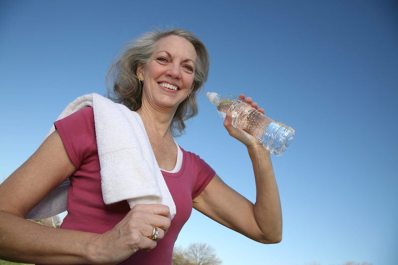 smiling active adult drinking water