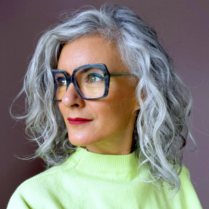 balayge inverse femme 60 ans cheveux mi longs gris lunette de vue pull vert