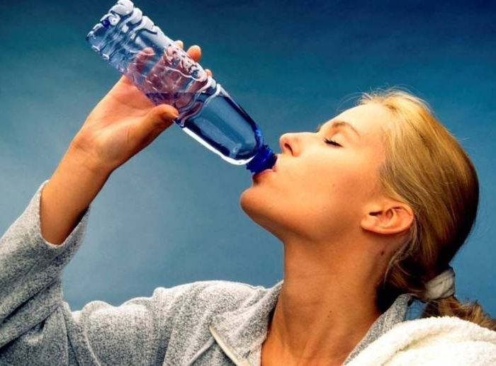comment eliminer le sel dans l organisme femme qui boit de l eau sur un fond blue