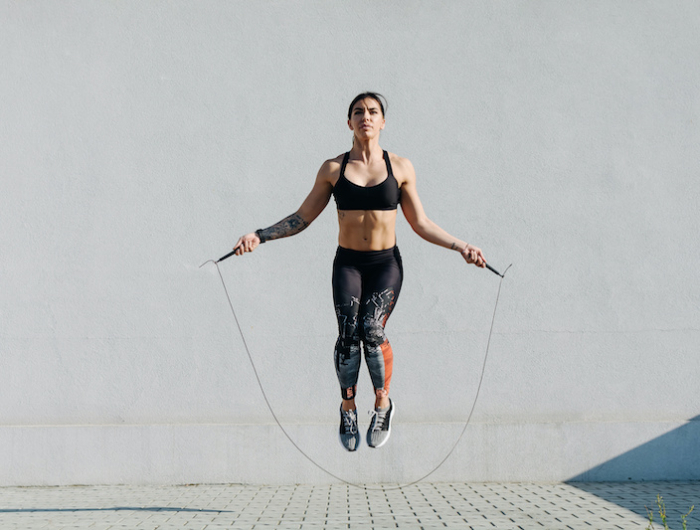 young woman skipping ropes outdoors