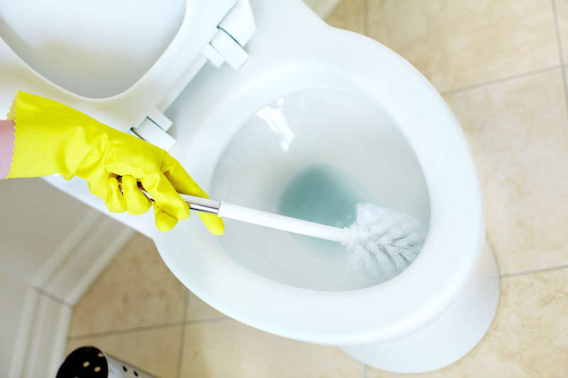detartrer toilette lessive de soude main en gant jaune
