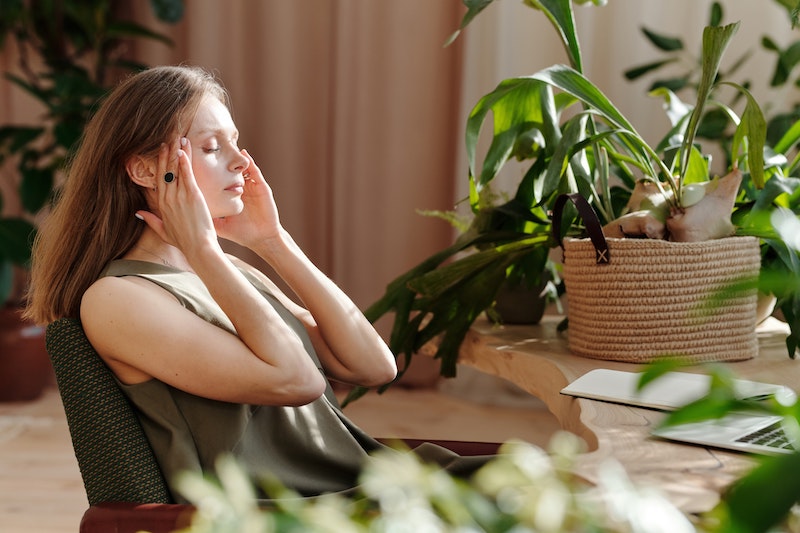 femme migraine dans son salon plantes vertes