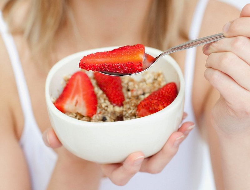 manger des fraise au petit dejeuner cuillere avec fraises dans un bol