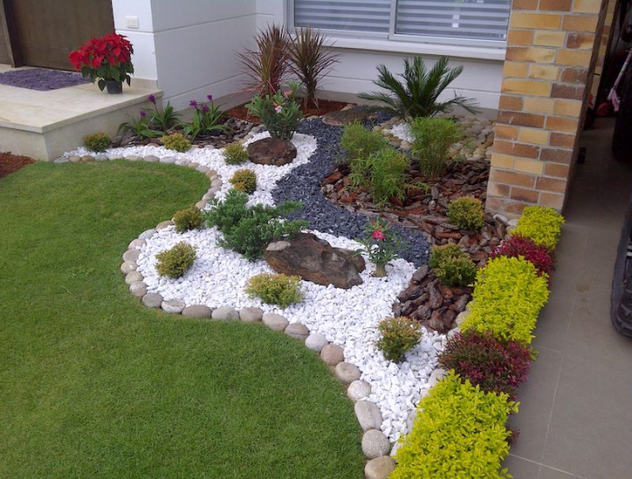 parterre avec cailloux jardin avec gazon vert et delarcation avec des galets blancs