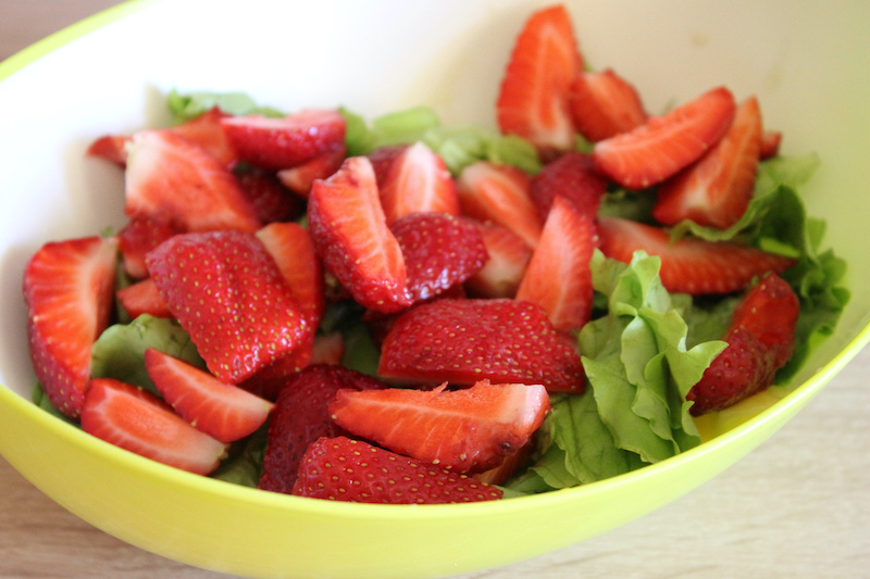 In the evening we can eat strawberries Green salad on a plate with strawberries