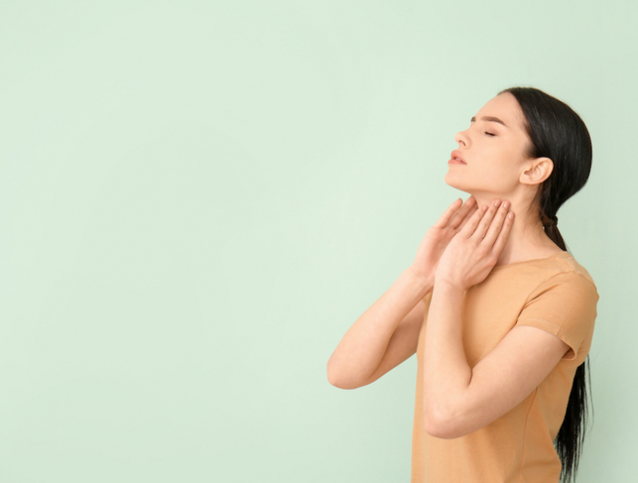 young,woman,with,thyroid,gland,problem,on,color,background