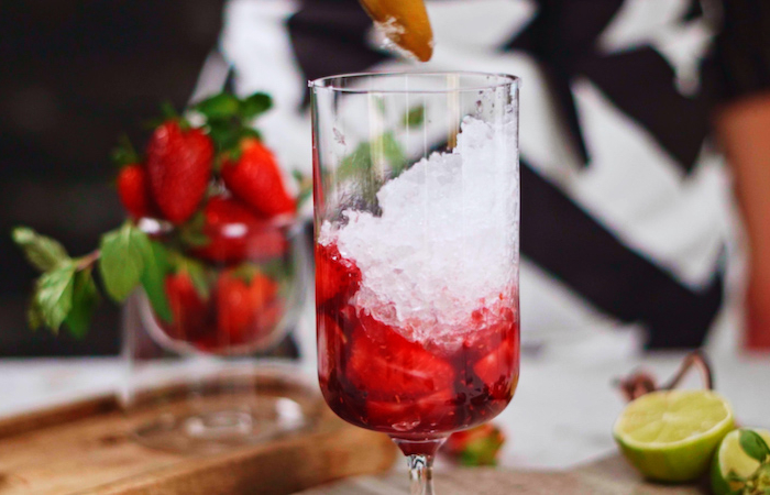 verser de la glace pilé dans le verre cocktail avec fraise et rhum mojito maison