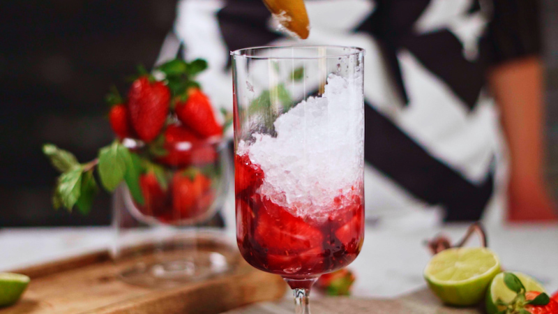 verser de la glace pilé dans le verre cocktail avec fraise et rhum mojito maison