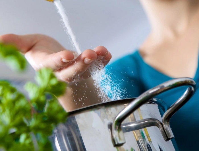 woman salting water 8 cooking mistakes making you fat