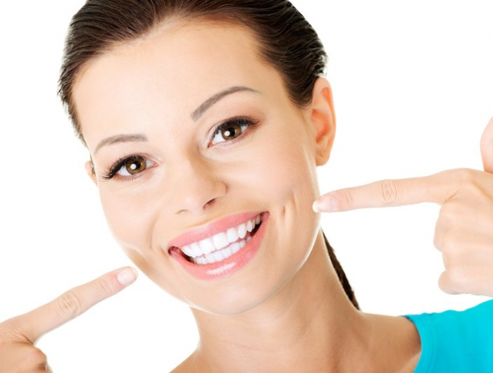 blanchir ses dents au bicarbonate et d autres secrets de grand mere femme souriante les doigts montrant ses dents