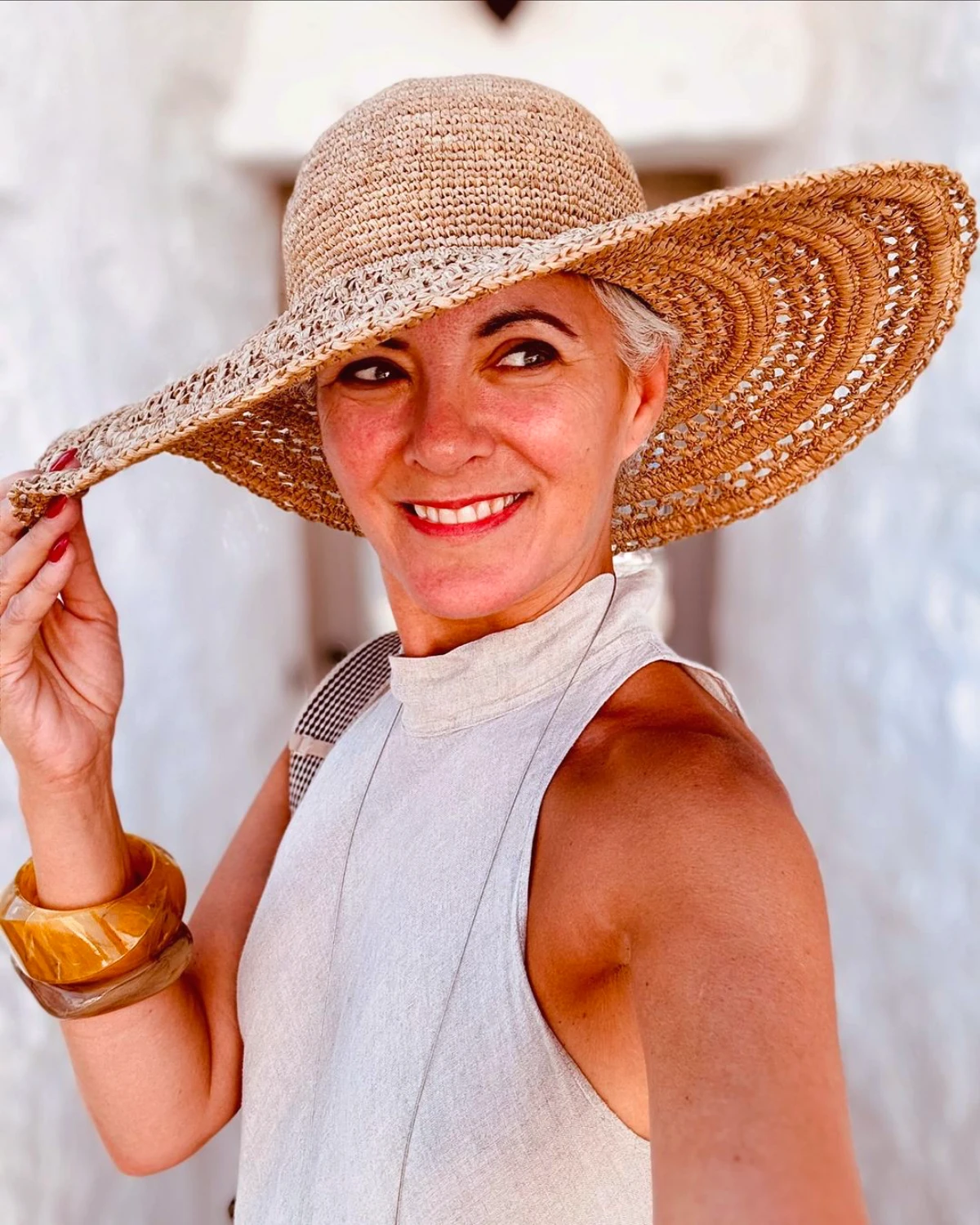 comment adopter le style boheme chic a 50 ans femme chapeau en paille top blanc bracelet en bois