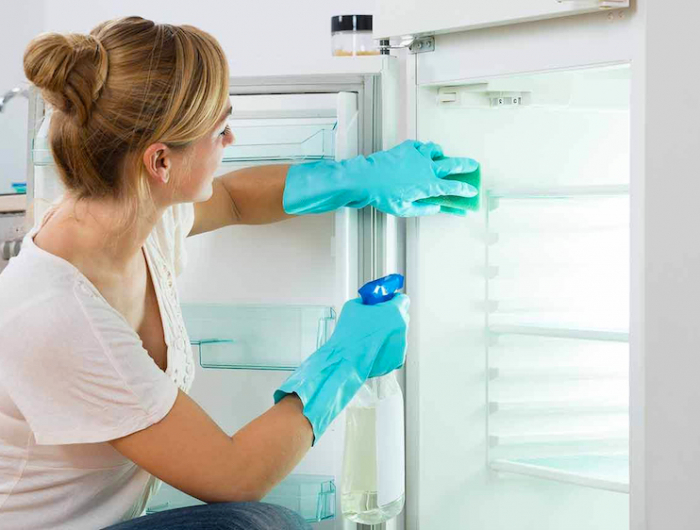 comment bien nettoyer le frigo femme au gangs bleus qui essuie