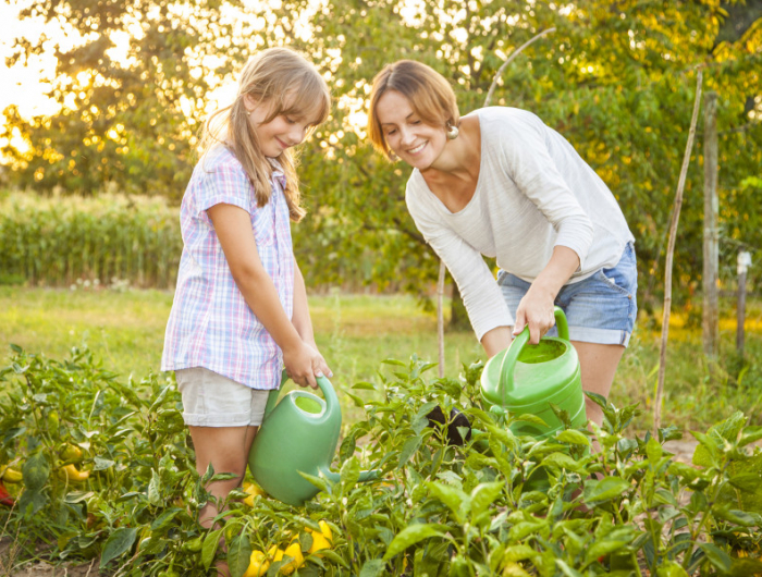 an image of a mother and daughter watering their garden