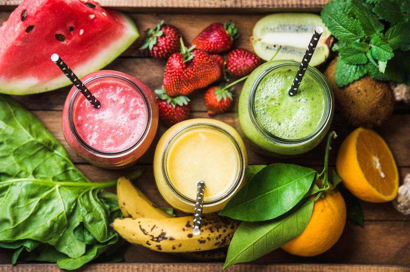 freshly blended fruit smoothies of various colors and tastes