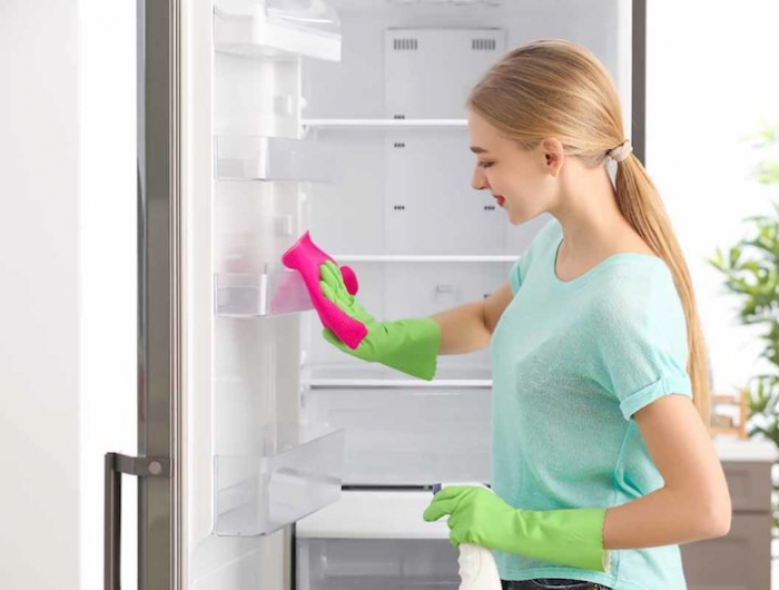 comment nettoyer le frigo astuces de grand mere femme au dos nettoyant un frigo aux gangs verts