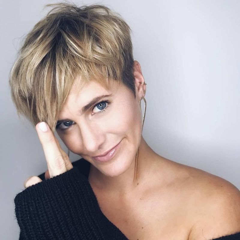 coupe pixie femme 50 ans avec des mèches blondes et frange longue asymétrique