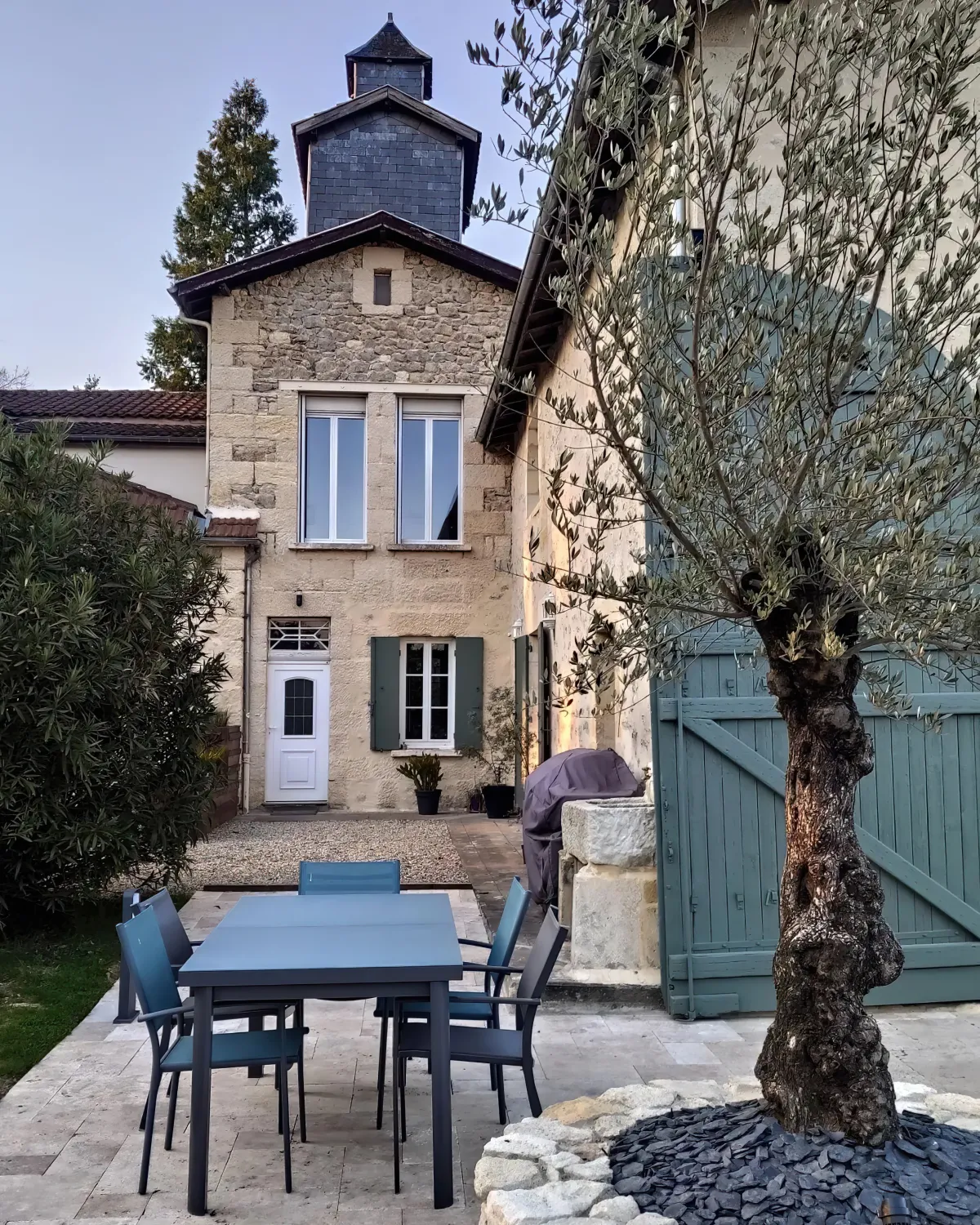 facade maison coin repas dans le jardin arbre et arbustes