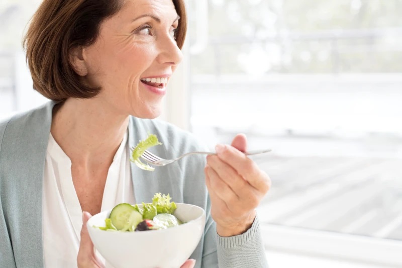femme a 40 ans mange de la salade verte
