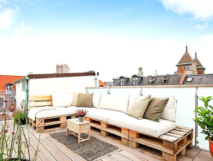 meuble exterieur en bois de palette sur un balcon de ville grand canape d angle et petite table basse