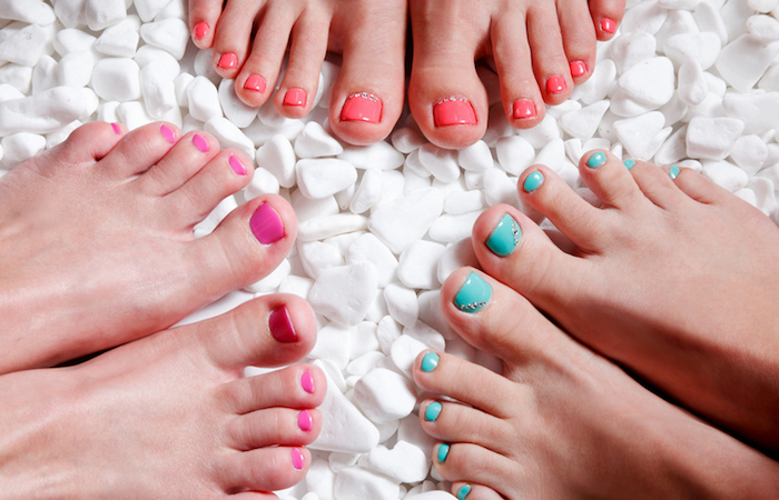 three people with brightly painted toenails