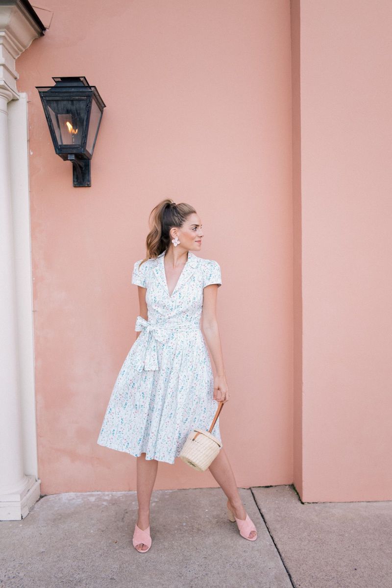 petite robe mi longuer avec des mules rose sur un fond de mur rose